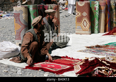 Afghan carpet sellers on the transborder market near Ishkashim on the border between Tajikistan and Afghanistan Stock Photo