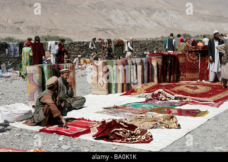 Afghan carpet sellers on the transborder market near Ishkashim on the border between Tajikistan and Afghanistan Stock Photo