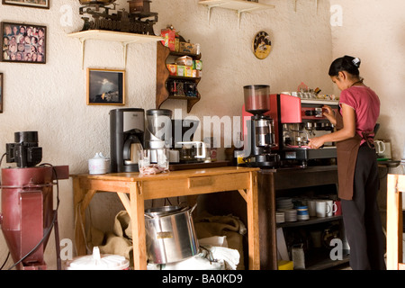 Guatemalan girl prepares fresh local coffee for patrons at a popular cafe in Antigua Guatemala Stock Photo