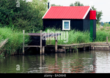 An hut with a red corrugated roof near Hickling Broad Norfolk Stock Photo