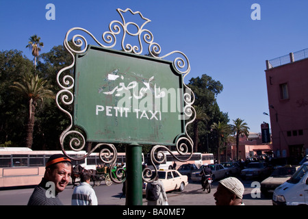 Taxi drivers wait for custom by a 'petit taxi' sign at a taxi rank near the place Jemaa El Fna in the Medina, Marrakech Stock Photo