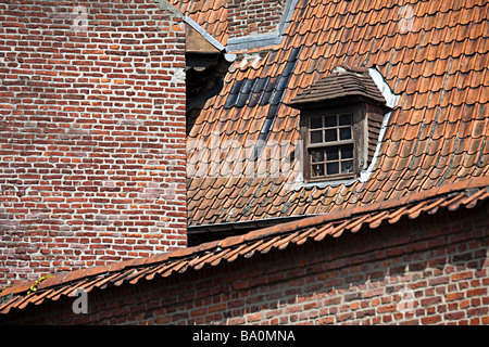 Garret window in tiled roof with old red brick walls Tournai Belgium Stock Photo