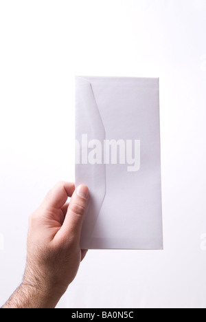 Hand holding a white envelope against a white background Stock Photo