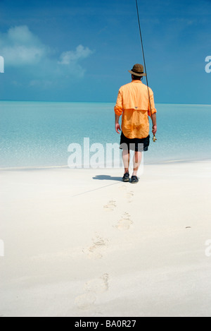 a fly fisherman walks to the flats for bonefishing in the exuma islands, bahamas Stock Photo