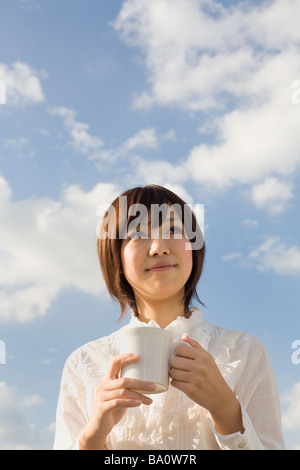 Young woman holding cup Stock Photo