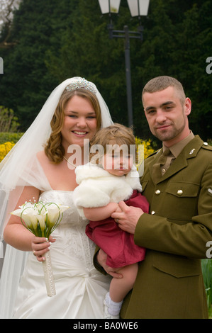 Bride and Groom in Army Uniform military armed forces wedding with Bridesmaid Stock Photo