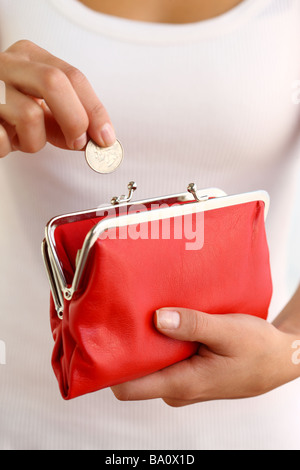 Hand of a woman with a red coin purse in the hands and coins in the ...