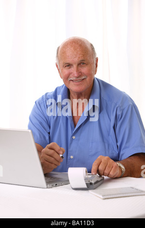 Senior man with laptop and calculator Stock Photo