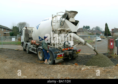 Pouring concrete from a cement mixer on a building site in England Stock Photo