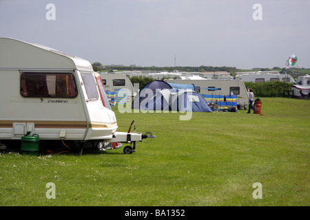 Caravans and tents in a sunlit field at a caravan site near Port Eynon, Gower, South Wales Stock Photo