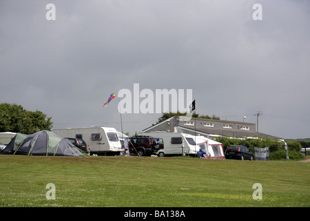 Touring caravans and tents against a dark stormy sky at a site near Port Eynon, Gower Peninsular, South Wales. UK. Stock Photo
