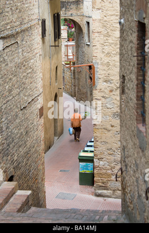 Local resident on the way home after visiting the market in the Piazza del Doumo, San Gimignano, Tuscany, Italy. Stock Photo