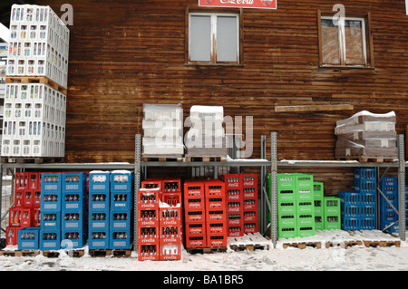 Crates of empty beer and drink bottles out side a snowy bar in the Swiss Alps Stock Photo