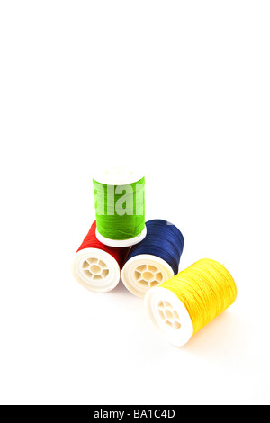 four multicolored spools on a white background Stock Photo