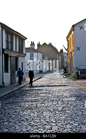 Two people walking along the cobbled street in Leigh on Sea in Essex Stock Photo