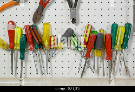 Tools hanging on wall above work bench Stock Photo