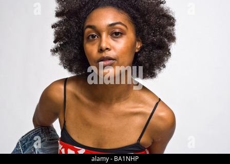 a young black woman leans forward and looks right into the camera Stock Photo