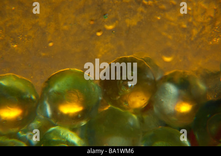 Macro closeup of glass marbles in a green glass vase. Stock Photo