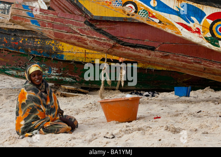 Woman on the Beach Next to Fishing Boats in Nouakchott Mauritania Stock Photo