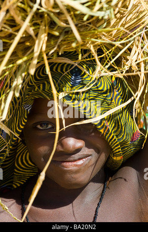 Young Malian girl carrying straw on her head in Djenne Mali Stock Photo