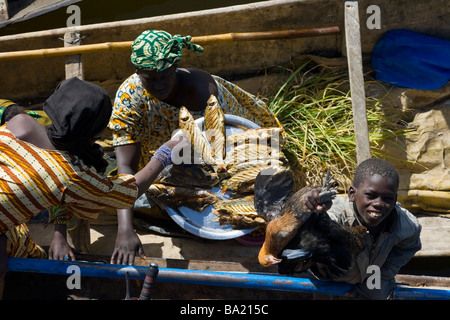 Vendor Selling to Malian Passenger on the Comanav Boat to Timbuktu on the Niger River in Mali Stock Photo