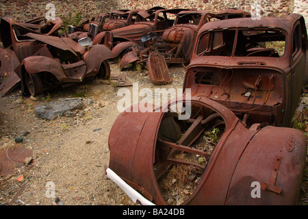 The remains of several burnt out old cars in the martyred village of Oradour sur Glane Limousin France Stock Photo