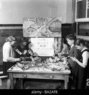 1950s, post-war Britain, children in a classroom making a model farm, with a sign about how food grown goes to the market, to shops and then to homes Stock Photo