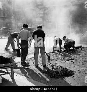 1950s,Paris, France, a group of French workmen repairing the road surface and laying hot tar on the famous Boulevard Haussmann, a famous Parisian ave. Stock Photo