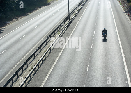 Lone Biker On An Empty Highway Stock Photo