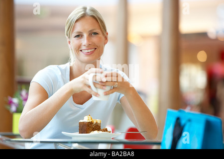 Woman Eating A Piece Of Cake At The Mall Stock Photo