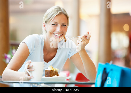 Woman Eating A Piece Of Cake At The Mall Stock Photo
