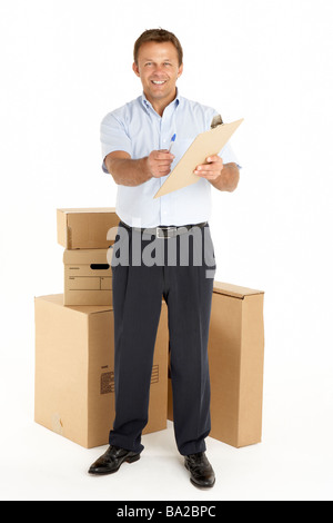 Portrait Of Courier Standing Next To Parcels, Holding A Clipboard Stock Photo