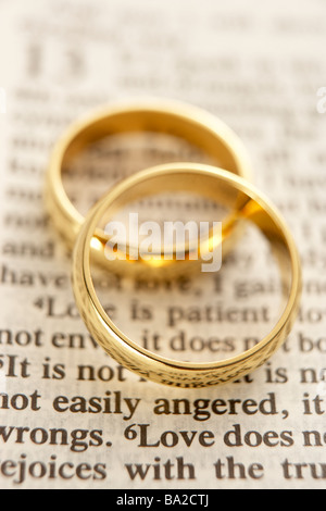 Two Wedding Rings Resting On A  Bible Page Stock Photo