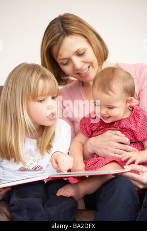 Mother And Daughters Reading Book Stock Photo