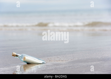 Message In A Bottle Buried In Sand On The Beach Stock Photo