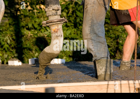 Construction workers pouring concrete at construction site Stock Photo