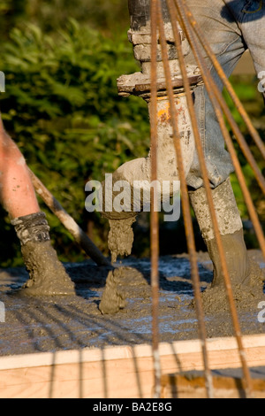 Construction workers pouring concrete at construction site Stock Photo