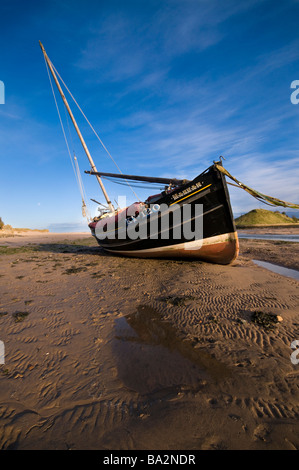 An old fishing boat moored in Alnmouth estuary at low tide 