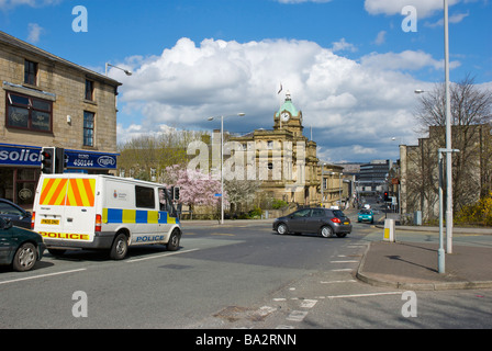 Police van approaching the Town Hall on Manchester Road, Burnley, Lancashire, England UK Stock Photo
