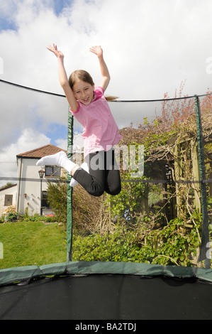 An 8 year old girl bouncing on a trampoline in Cornwall, UK Stock Photo