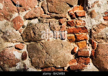 Hole in stone wall filled with bricks. Stock Photo