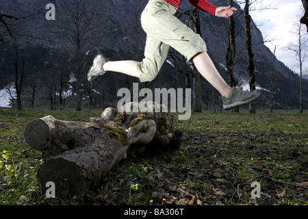 Woman young runs detail legs jump log at the side forest series people 20-30 years leisurewear athletically movement runs Stock Photo