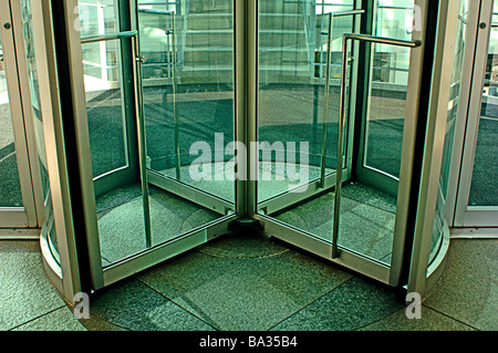 Revolving glass door into a modern commercial building Stock Photo