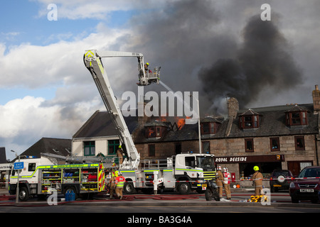 Firemen fighting Shop fire. Firefighter at scene at George Strachan’s of Aboyne, Aberdeenshire, Scotland Stock Photo