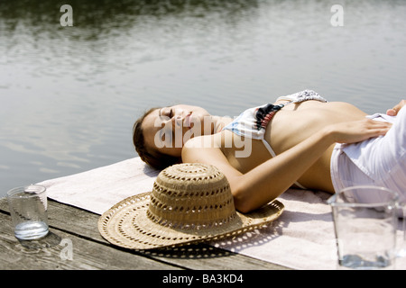 Lies woman young bikini-top bridge sunbathes series people 24 years 20-30 years brunette straw hat hat bikini summery summers Stock Photo