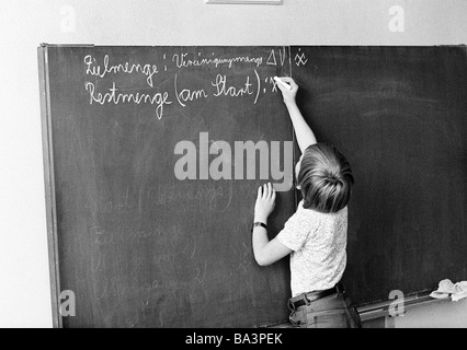 Seventies, black and white photo, edification, school, schoolboy in a school class during lessons, children aged 7 to 8 years, boy at a blackboard, set theory Stock Photo