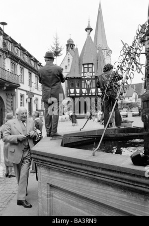 Achtziger Jahre, Urlaub, Tourismus, Hobbyknipser stehen am und auf dem Marktbrunnen und fotografieren das Rathaus und die Stadtkirche von Michelstadt, Stock Photo