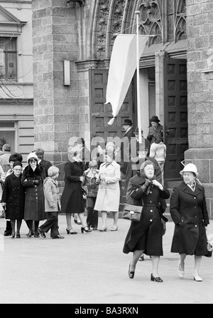 Seventies, black and white photo, religion, Christianity, church goers leaving the church after the worship service, church portal, flag Stock Photo