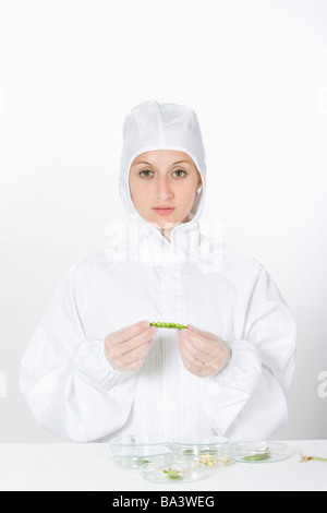 One woman wearing protective suit holding pea Stock Photo