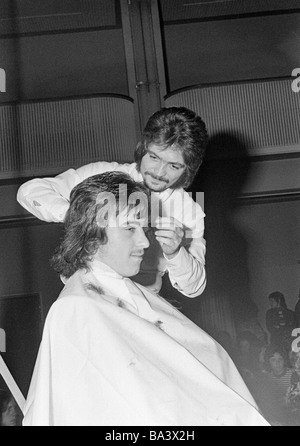 Seventies, black and white photo, cultural event 1971 in the Lichthof of the trade school Bottrop, fashion show, hairdressing contest, barber working with a juvenile model, man, aged 25 to 30 years, boy, aged 18 to 25 years, D-Bottrop, Ruhr area, North Rhine-Westphalia Stock Photo
